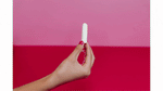 Hands demonstrating a tampon being opened up